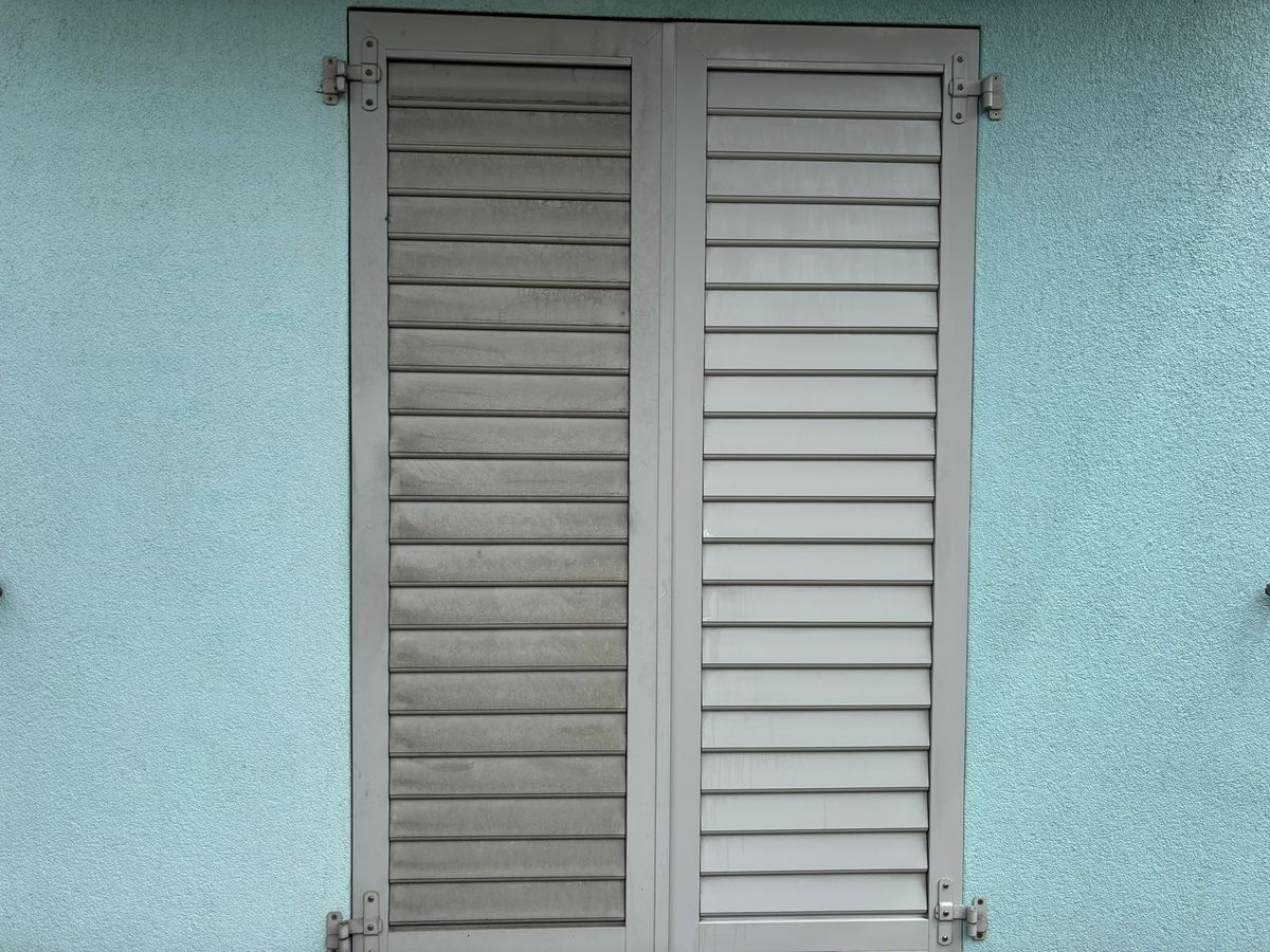 Aluminium-Fensterladen links verschmutzt und rechts gereinigt